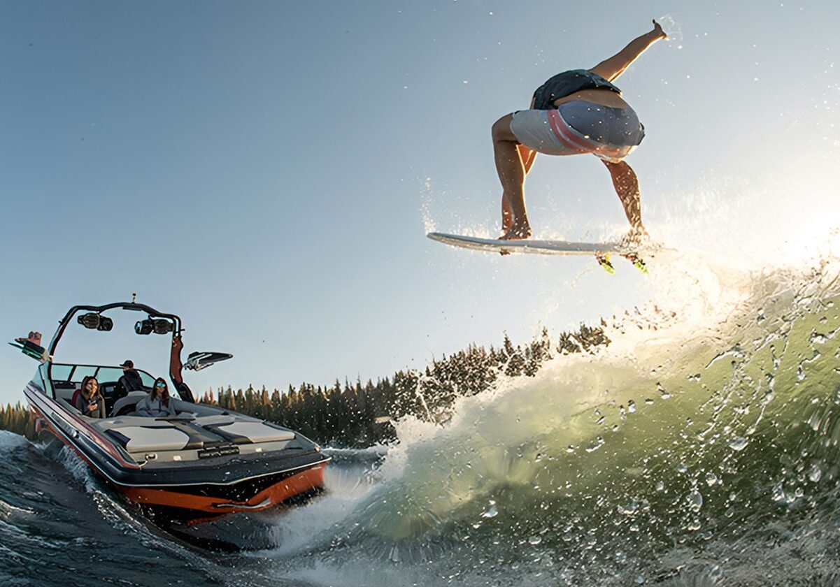 Speedboat towing wakeboarder over waves